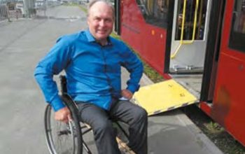 Автор статьи в инвалидном кресле у автобусной остановке