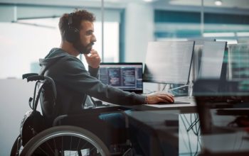 Мужчина в инвалидном кресле работает за компьютером