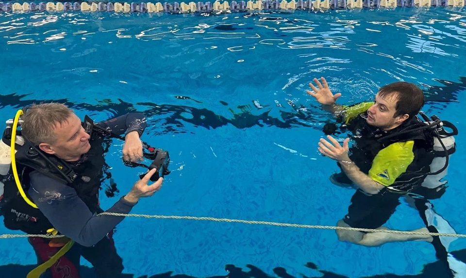 Участник СВО занимается с инструктором дайвингом в бассейне